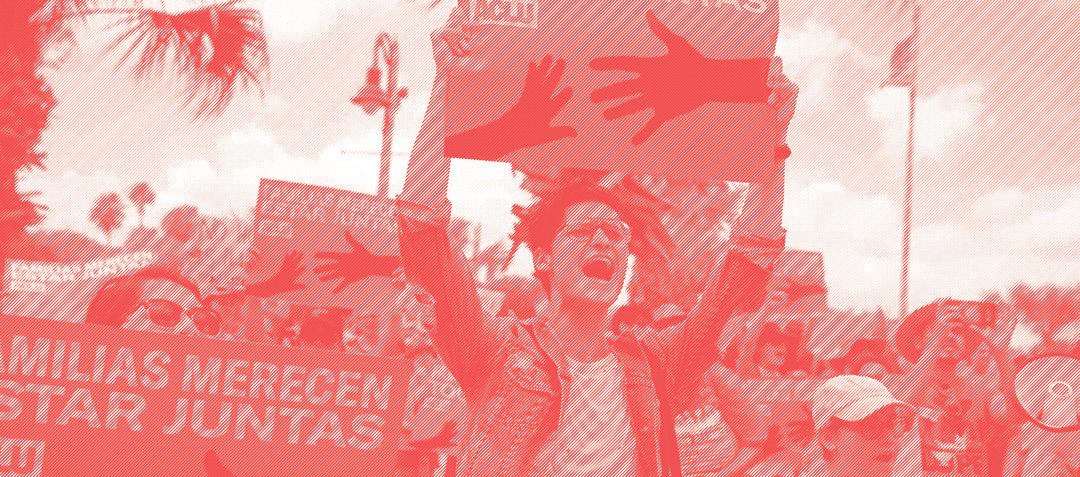 Image of an individual holding a protest sign in Spanish