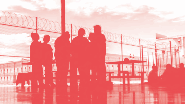 Image of people standing in a detention facility