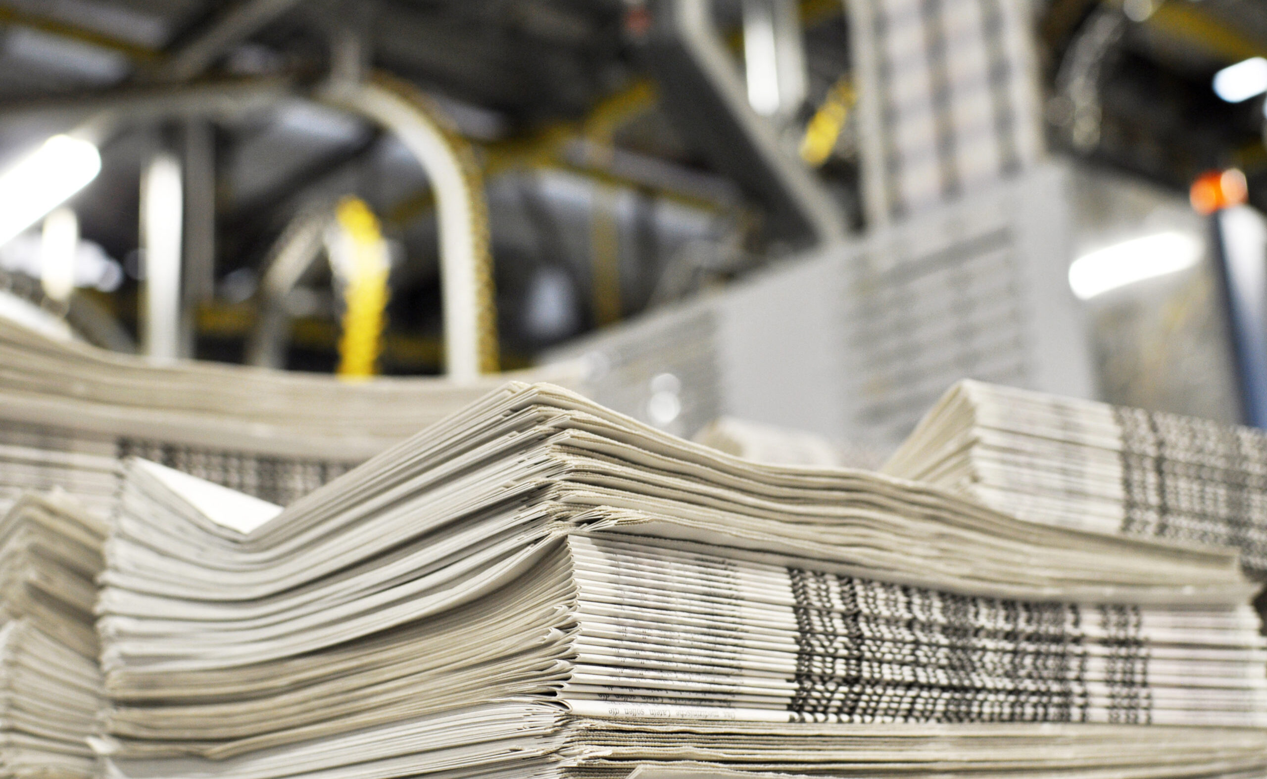 Image of a stack of newspapers in a warehouse.