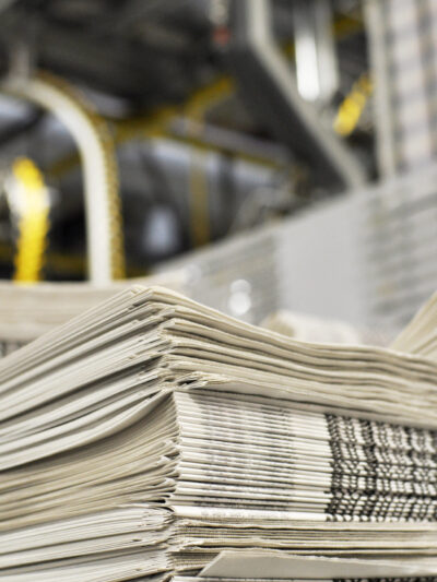 Image of a stack of newspapers in a warehouse.