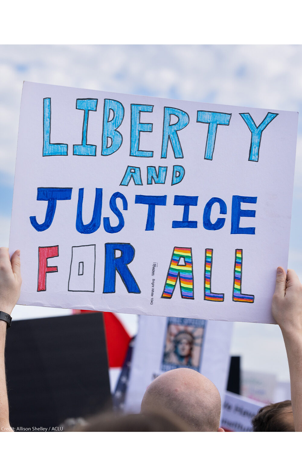 A demonstrator holds up a sign that reads, "LIBERTY AND JUSTICE FOR ALL" at the No Kings National Day of Action protest near the U.S. Capitol building in Washington, D.C., October 18, 2025.