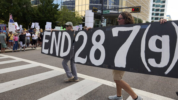 People in Florida carry a sign calling for an end to 287(g).