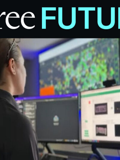 A police officer looking at a wall full of screens in a crime center showing maps and data