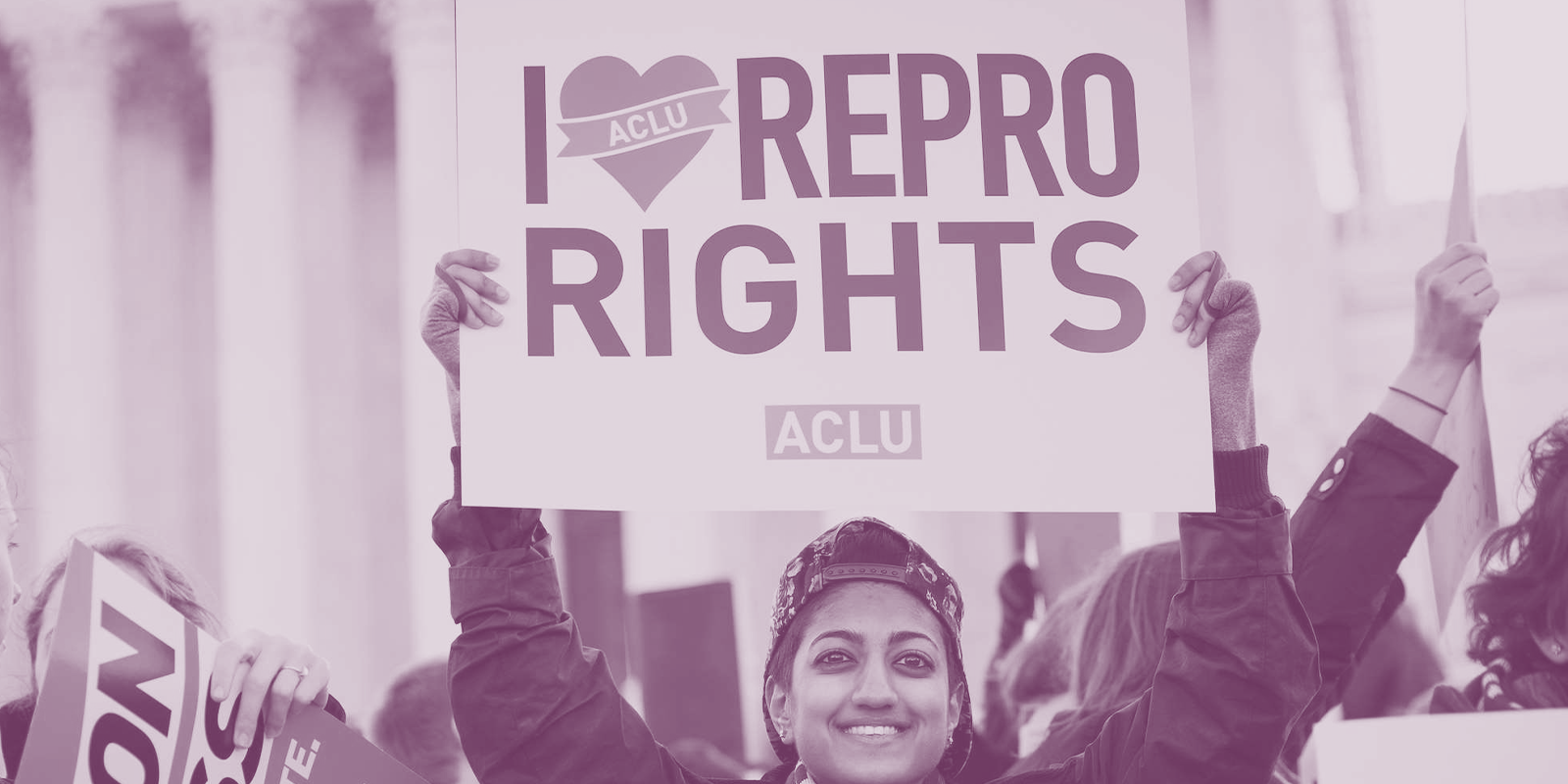 Image of a person holding a protest sign that reads, "I love repro rights."