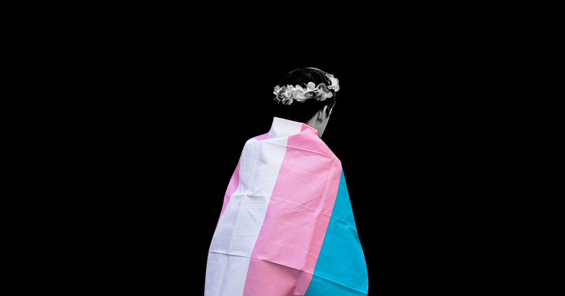 Image of a person holding a trans flag
