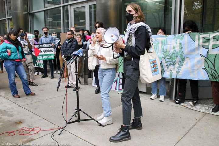 Individuals from Students for Justice in Palestine speak at the Boot Boeing! Free Palestine march and rally while they block all the entrances to Governor Pritzker's Chicago office in downtown Chicago.