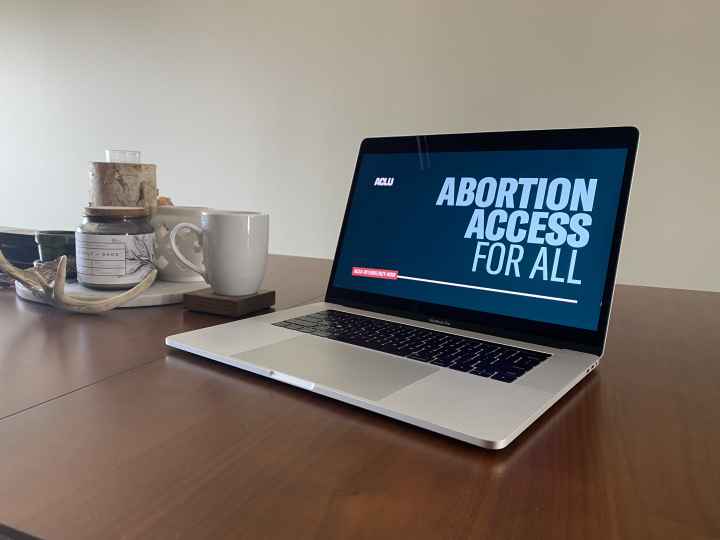 Image of a laptop with the background, "ABORTION ACCESS FOR ALL."