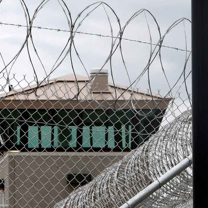 A guard tower over the fence at a correctional health care facility.
