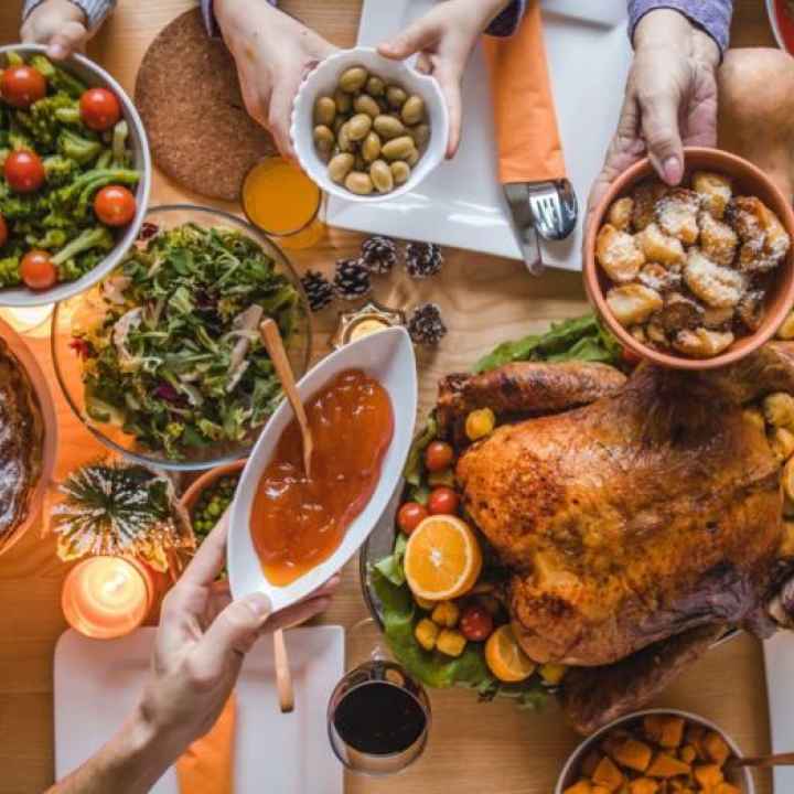 holiday dinner table with hands passing food