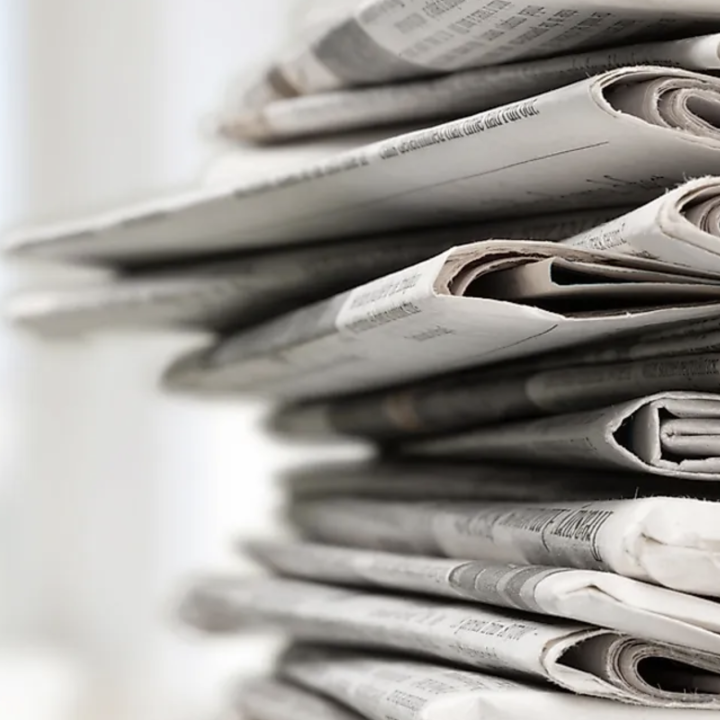 Image of a stack of newspapers, off to the right.